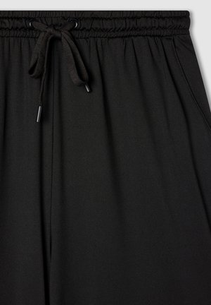 Pantaloni sportivi neri realizzati in morbido tessuto, con vita elasticizzata, chiusura con cordino e tasche laterali. Texture liscia e vestibilità comoda.