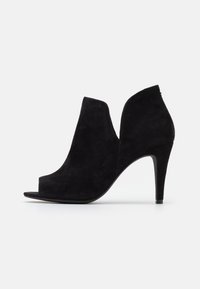 Zapato de tacón de ante negro con punta descubierta, que presenta un diseño curvado, una silueta elegante y un alto tacón de stiletto. Acabado con un corte.