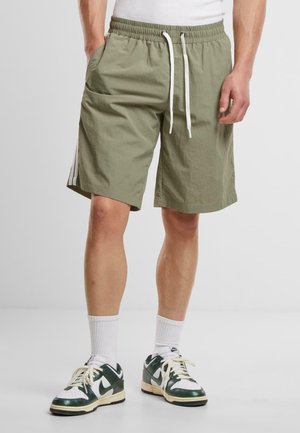 Shorts kaki avec une taille élastique et un cordon de serrage blanc, dotés de poches latérales et de bandes blanches sur les jambes.