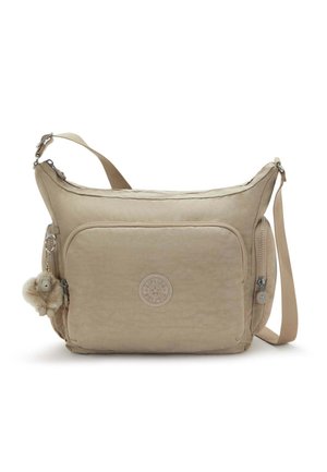 Bolso bandolera beige con un tejido suave y texturizado. Cuenta con un bolsillo frontal con cremallera, un logo bordado y un colgante decorativo.