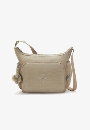 Beige crossbody bag with a soft, textured fabric. Features a front zipper pocket, embroidered logo, and a charm pendant for detail.