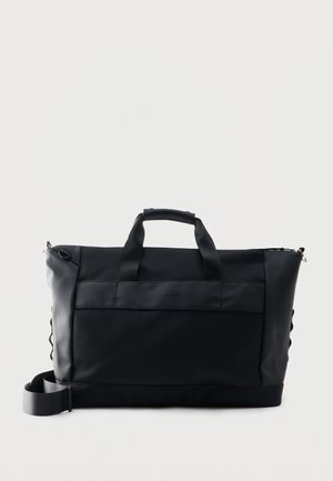 Must ristkülikukujuline spordikott, millel on ülemised sangad, reguleeritav õlarihm ja eesmine tasku, toodud esile ühevärvilise hele tausta vastu.