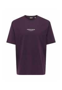 Lilla bomulds T-shirt med korte ærmer, med en rund halsudskæring og hvid trykt tekst "CURATED STAPLES" over brystet.