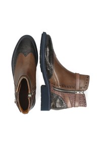 Botas de tobillo de cuero marrón y negro con patrones texturizados, cremallera lateral, perforaciones decorativas y suelas de goma oscura, mostradas desde vistas superior y lateral.