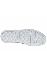White rubber sole with textured pattern, featuring a shield logo and horizontal grooves for traction. Smooth edges and reinforced heel.