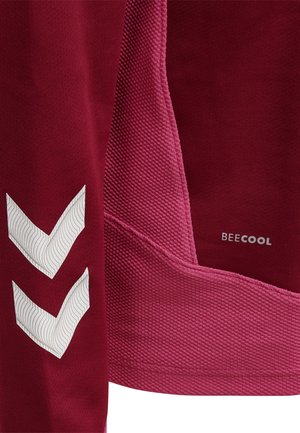 Close-up van bordeaux getextureerde stof met twee witte chevrons en kleine "BEECOOL" tekst gedrukt aan de rechterkant.