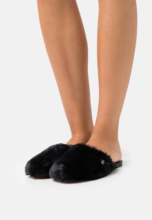 Svarta fluffiga tofflor med öppen hälen, med mjuk textur och subtila guldfärgade detaljer. Designen är rundad vid tån.