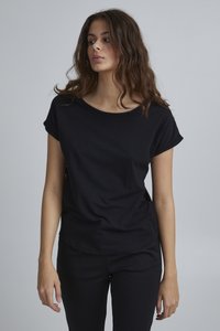 Schwarzes T-Shirt mit kurzen Ärmeln aus weichem Stoff, mit Rundhalsausschnitt und aufgerollten Ärmeln, kombiniert mit schwarzen Hosen. Schlichtes, minimalistisches Design.