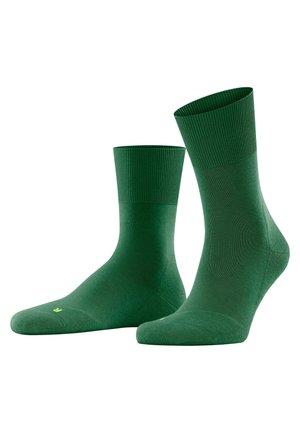 Green socks with a ribbed cuff, a smooth texture, and a lightweight design. Features a small yellow logo on the sole.