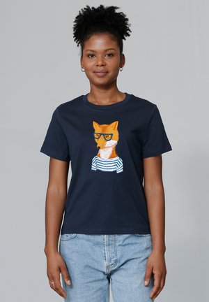 T-shirt en coton bleu marine avec un graphique de renard orange portant des lunettes et une chemise rayée. Col rond classique et manches courtes.