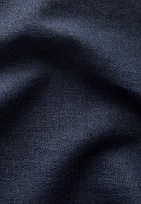 Suvetise sinine kangas tekstuurse koega, näidates pehmeid voltse ja õrna valguse peegeldust, mis viitab siledale, keskmise kaaluga materjalile.