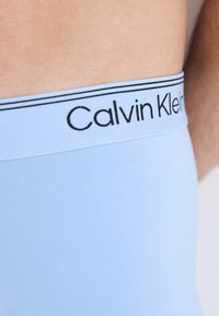 Himmelblaue Boxershorts mit einem schwarzen Calvin Klein-Logo auf dem elastischen Bund. Glattes Material mit einer schmalen Passform und minimalen Nähten.