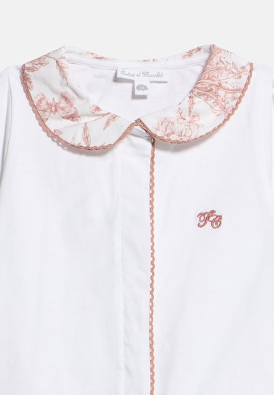 Λευκό βρεφικό πουκάμισο με στρογγυλεμένο γιακά με λουλουδένιο σχέδιο, καφέ σκαλοπάτι και κεντημένα αρχικά "LC" στο στήθος.