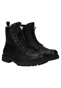 Pár černých kožených šněrovacích bot s robustními podrážkami, vysokou podporou kotníků a poutky vzadu.