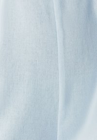 Jasnoniebieska, teksturowana tkanina z drobnym wzorem splotu o gładkim wykończeniu. Powierzchnia wydaje się miękka i lekka.