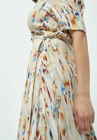 Fließendes Kleid aus weichem Stoff mit abstraktem Muster in Beige, Blau und Braun. Geraffte Taille mit Bindeband, kurze Ärmel.