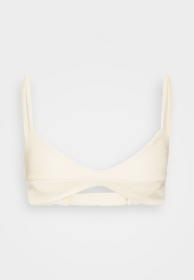 Haut de bikini en crème côtelé avec des bretelles ajustables étroites, mettant en valeur un détail découpé au centre et un tissu texturé pour un maintien optimal.
