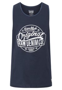 Mørkeblå ærmeløs tanktop lavet af bomuld, med en hvid cirkulær grafik med tekst, og et mærke på den nederste side.