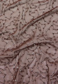 Brązowa siateczkowa tkanina z wirującym wzorem z metalicznymi koralikami, tworząca teksturowaną powierzchnię z błyszczącymi, refleksyjnymi akcentami na całej powierzchni.