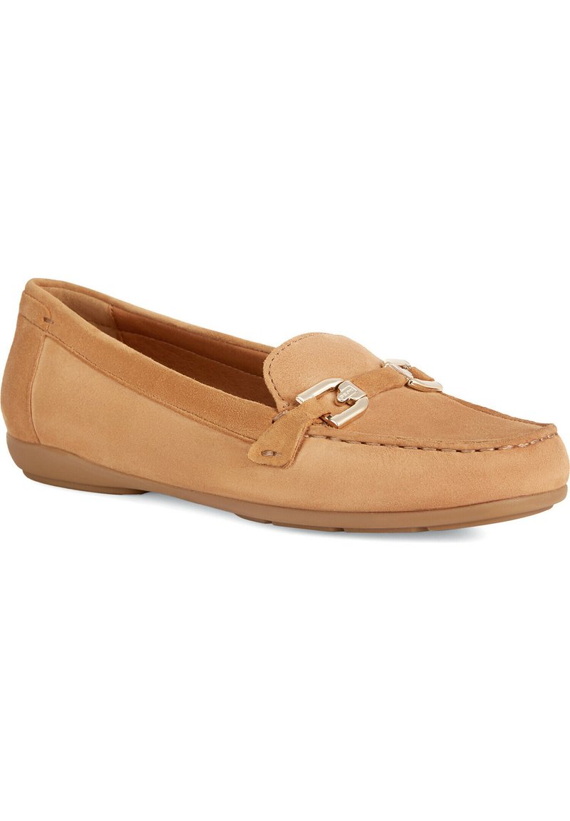 Mocassin plat en suede beige avec un bout arrondi, des embellissements métalliques décoratifs et des coutures le long des bords. Semelle flexible.