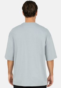 Lichtblauw, T-shirt met korte mouwen en een ontspannen pasvorm, ronde hals en effen textuur, met een rechte zoom en doorgezakte schoudernaden.