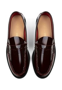 Mocassini in pelle bordeaux lucida con suola nera piatta, caratterizzati da un'accurata lavorazione delle cuciture e un classico design con fessura per moneta.