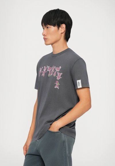 Pilkas trumpas rankovėmis t-shirt su rožine ir žalia grafika priekyje. Minkšta medvilnės medžiaga, laisvas pjūvis ir etiketė kairėje rankovėje.