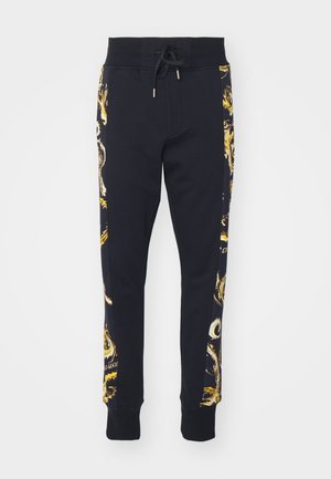 Pantaloni della tuta neri con motivo grafico dorato sui lati, vita elastica con cordoncino e polsini a costine. Realizzati in materiale morbido.