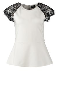 Blouse blanche avec manches courtes en dentelle noire et ourlet péplum, dotée d'un col rond et d'une fermeture éclair au dos.