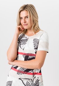 Korte mouwen jurk met een crèmekleurige basis, zwarte bloemenpatronen, rode strepen en een ronde halslijn. Gladde stof met een subtiele glans.