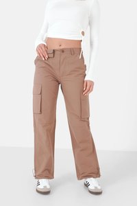 Beige cargobroek met zijzakken, met een recht model en verstelbare enkeltouwen. Draag het met een wit langarmshirt en sneakers.