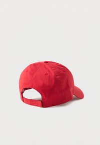 Κόκκινο μπέιζμπολ καπέλο που φαίνεται από πίσω με υφασμάτινο λουρί και μεταλλικό κούμπωμα σε λευκό φόντο.