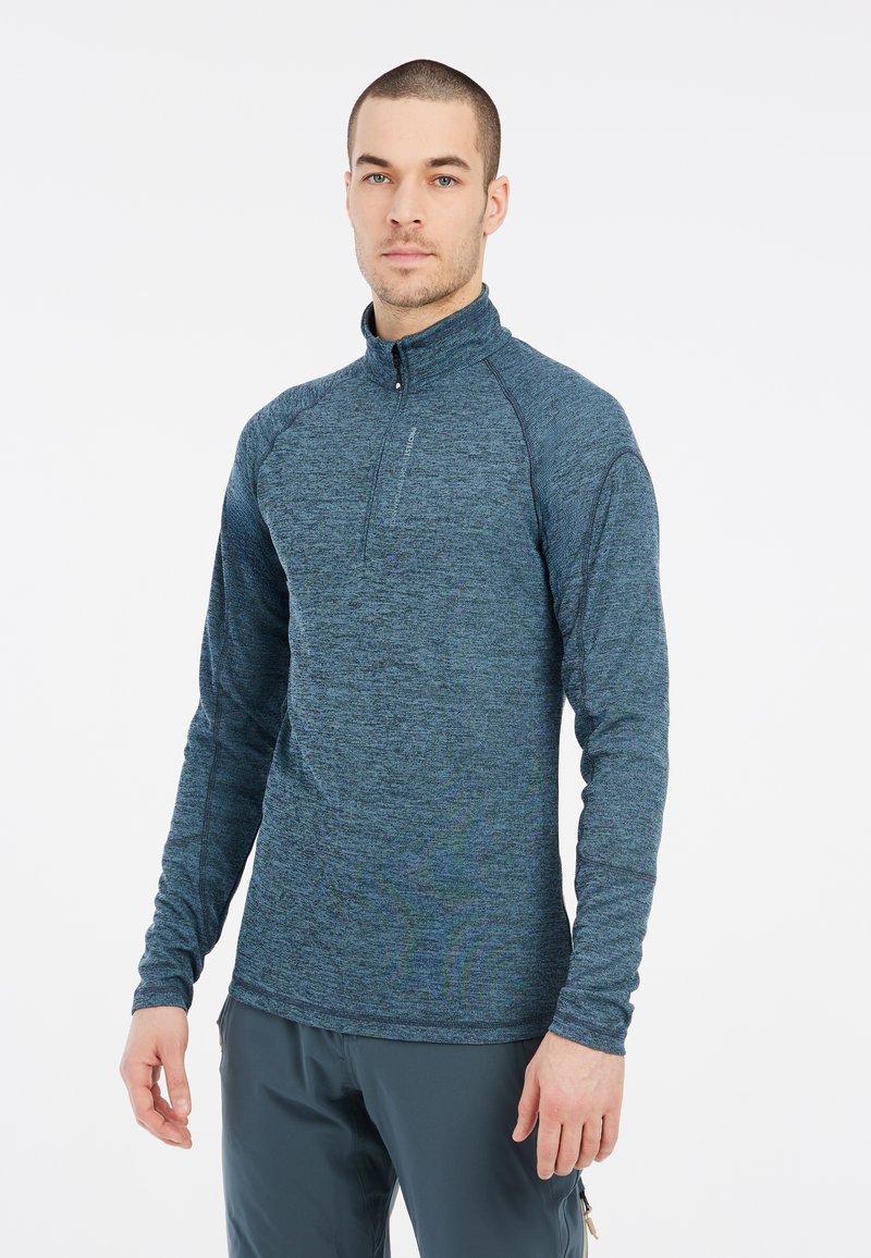 Top da uomo a maniche lunghe con zip a quarti in un tessuto blu scuro testurizzato. Presenta un colletto alto e cuciture sottili per un tocco di dettaglio in più.