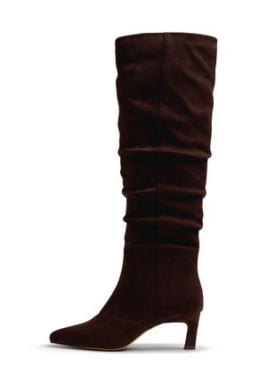 Stivale da donna alto in camoscio marrone scuro con tacco sottile di altezza media e gambale leggermente sceso su sfondo bianco.