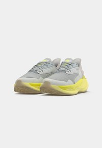 Grå mocka och mesh sneakers med en gul sula, med en rund form, strukturerad yta och snörningssystem med kontrasterande accenter.