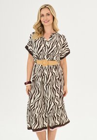 Korte mouw midi-jurk in een zebra-print, met een knoopsluiting aan de voorkant en een taille die is cinched met een geweven riem. Kleurenpalet: crème en bruin.