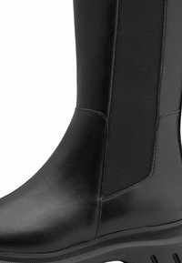 Botte chelsea en cuir noir avec des panneaux latéraux en élastique et une semelle en caoutchouc texturée. Supple supérieur avec des coutures discrètes.