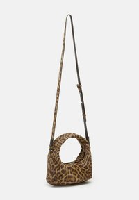 Sac bandoulière en tissu à motif léopard avec un design arrondi et creux. Il est doté d'une fine sangle ajustable et d'une fermeture éclair.
