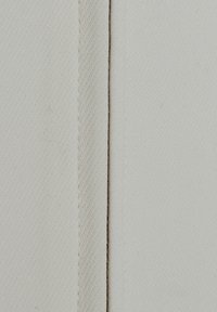 Tessuto di cotone in off-white con una sottile trama, caratterizzato da una cucitura dritta e un filo sottile in contrasto che corre lungo il bordo.