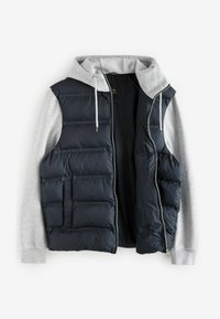 Gilet matelassé marine avec des manches de sweat à capuche gris, présentant une fermeture éclair à l'avant, des poches latérales et une texture matelassée. L'intérieur est sombre et doublé.