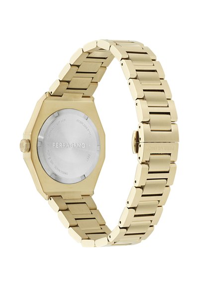Zelta metāla saites pulkstenis ar sešstūra formas korpusa aizmuguri, kurā iegravēts "FERRAGAMO", un nerūsējošā tērauda aizmugures vāciņu.
