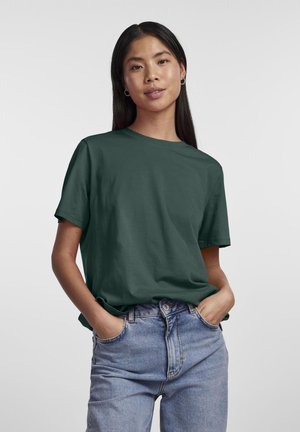 T-shirt verde-escuro de manga curta com decote redondo, feito de tecido de algodão, combinado com jeans de cintura alta azul claro. Design limpo, sem padrões.