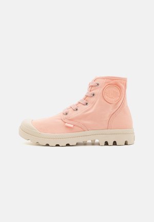 High-top canvas boots in pastel pink, featuring round lace-up design, rubber toe cap, textured fabric, and a patterned sole.