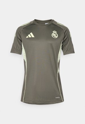 Sötétzöld sportmez világoszöld kiegészítőkkel, rövid ujjú, kerek nyakú, a mellkasán a Real Madrid logóval. Nedvességelvezető anyagból készült.