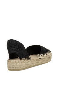 Espadrille negra con parte superior tejida, suela de cuerda de yute y detalles de costura. Diseño de espalda abierta con acentos de tela texturizada para mayor agarre.