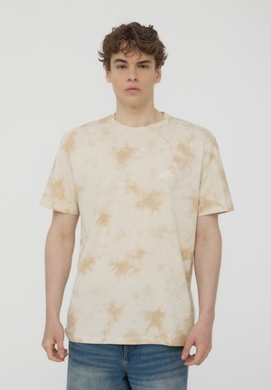 T-shirt w kolorze kremowym i brązowym w stylu tie-dye, z krótkimi rękawami, okrągłym dekoltem i małym logiem na klatce piersiowej. Wykonany z miękkiej bawełny.