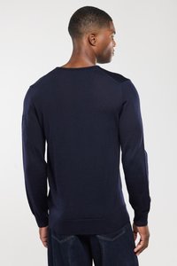 Navyblauer Strickpullover mit langen Ärmeln, gerippten Bündchen und Saum, glatter Textur und rundem Halsausschnitt; dezente Schulterakzente.