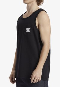 Zwart tanktop van katoen, met een ronde halslijn en een borstzak aan de linkerkant met een witte logoprint. Eenvoudig, mouwloos ontwerp.