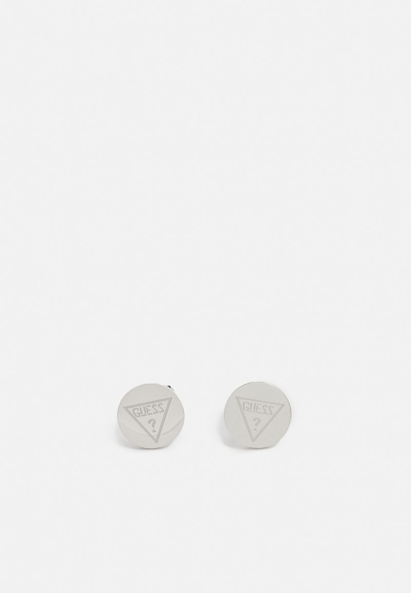 Paire de boutons de manchette ronds de couleur argent gravés du logo triangulaire de la marque Guess et d'un point d'interrogation au centre.