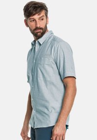 Lichtblauw, kortemouwen overhemd met knoopsluiting van een textuurstof, borstzak en subtiele branding aan de voorkant. Casual, iets getailleerd ontwerp.